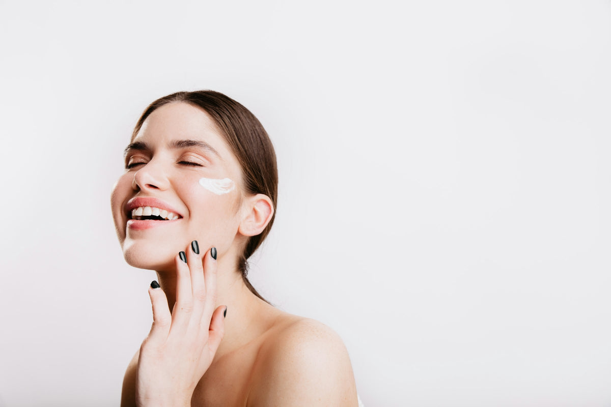 Woman smiling with her hand to her glowing face